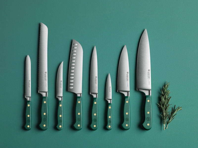 Set of knives with green handles on a teal background