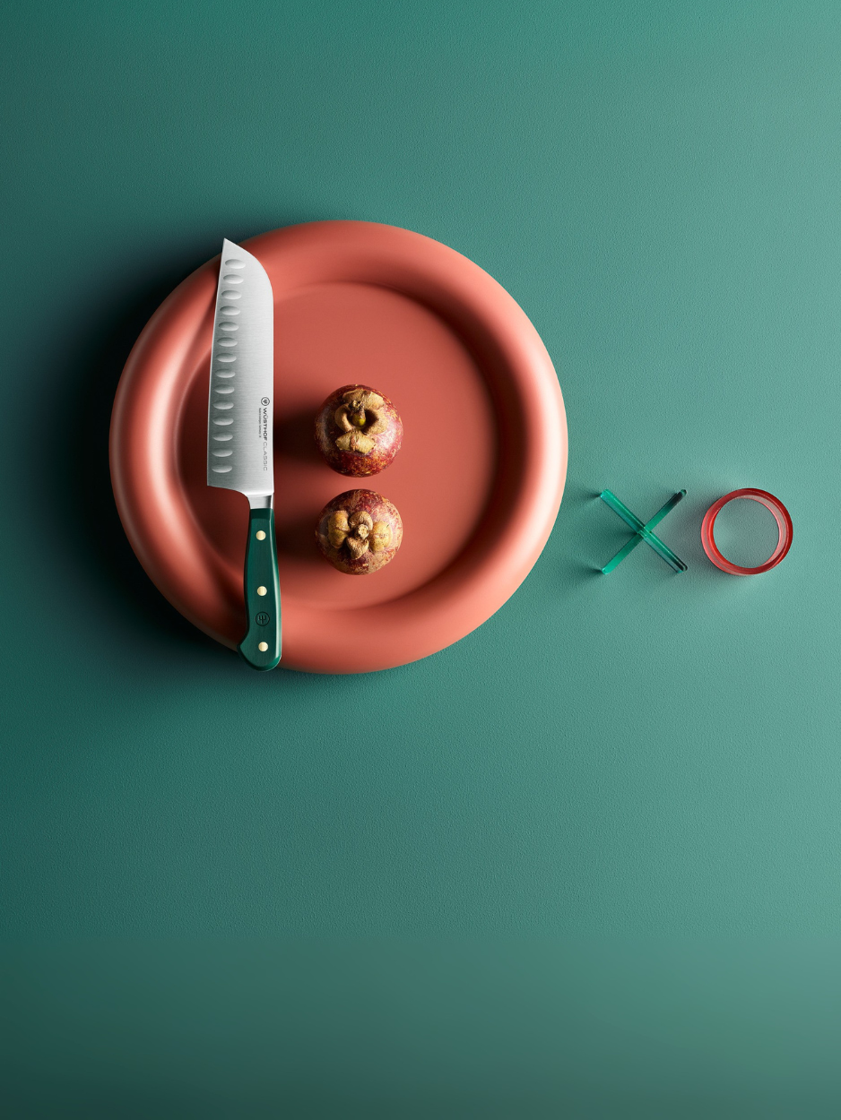 Red plate with a knife and apples on a green background