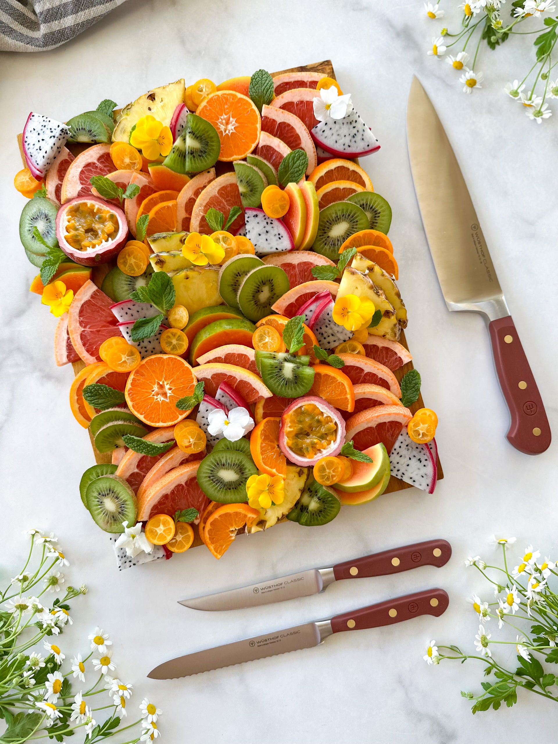 Fruit salad with a knife on a marble surface