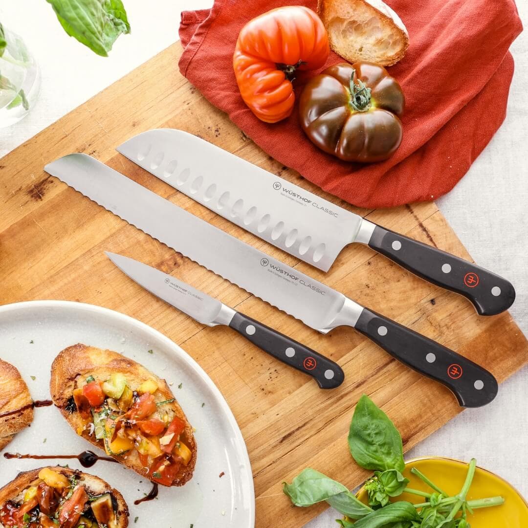 Several Wusthof knives of various types next to prepared food