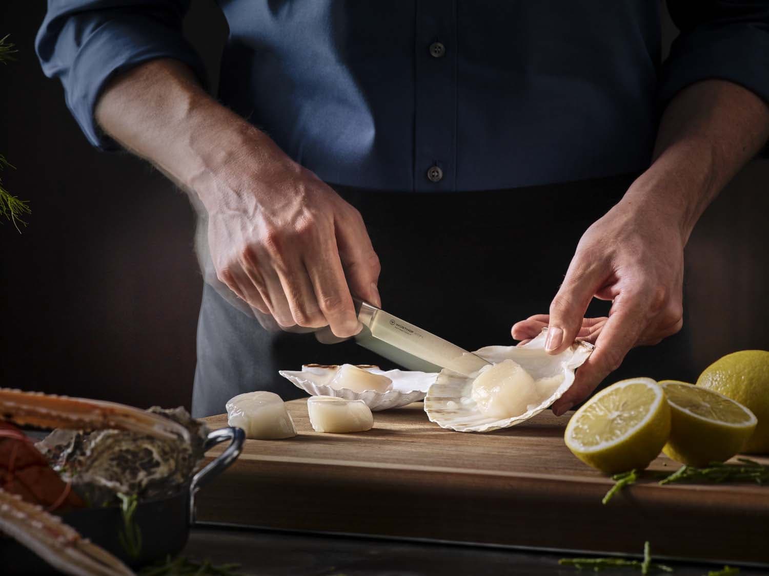 preparing scallops with an ikon knife in motion