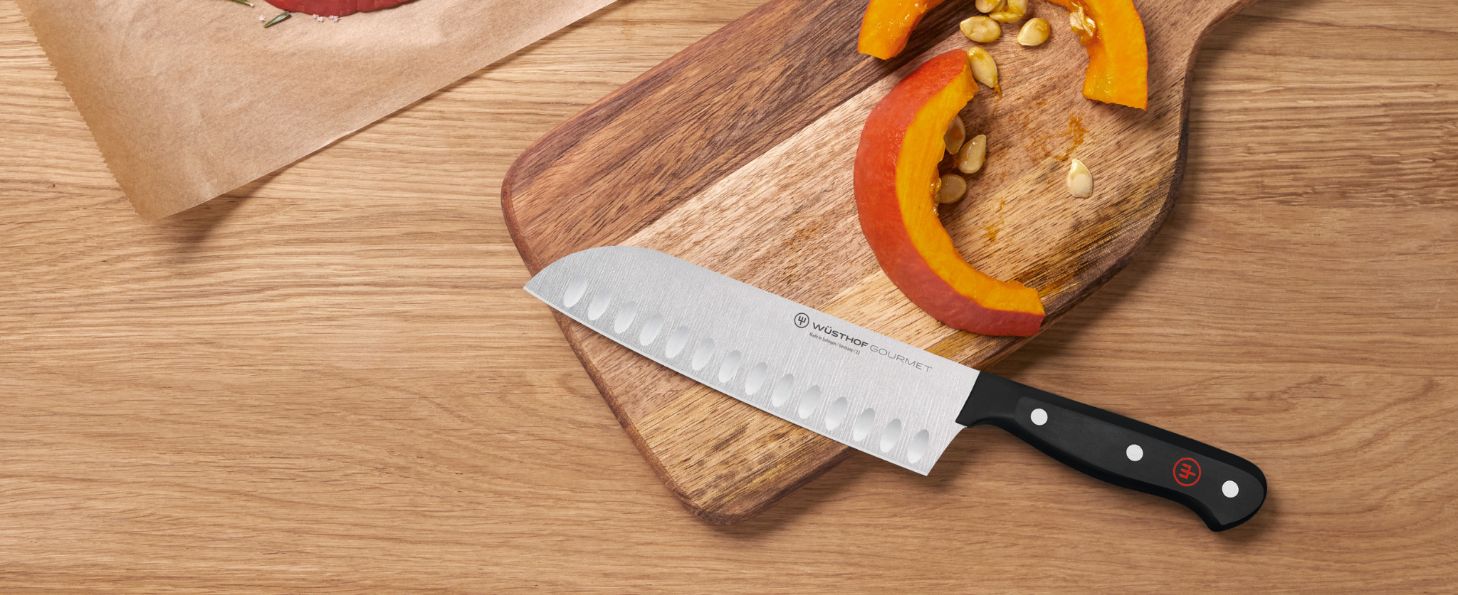 santoku knife on cutting board near sliced fruit