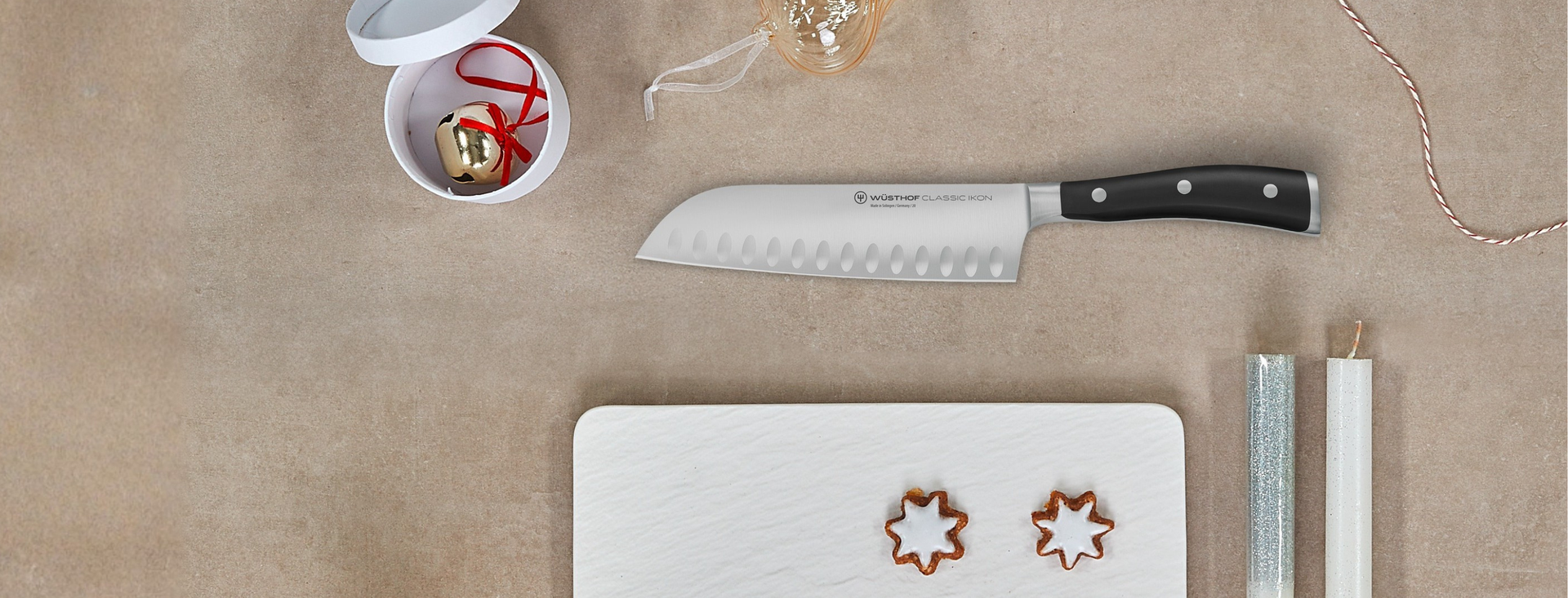 knife on brown background with white cutting board and holiday bell.